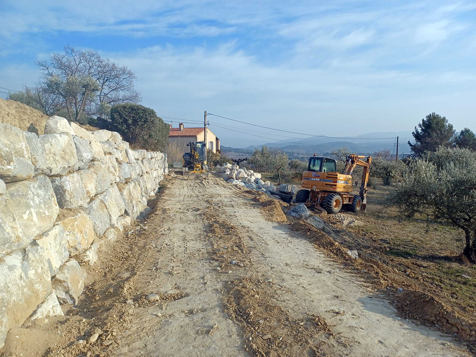 Réalisations Arrachage de vignes par GUILLAUME TP. Terrain avec le Bull au milieu de plusieurs tas de cep de vignes arrachés