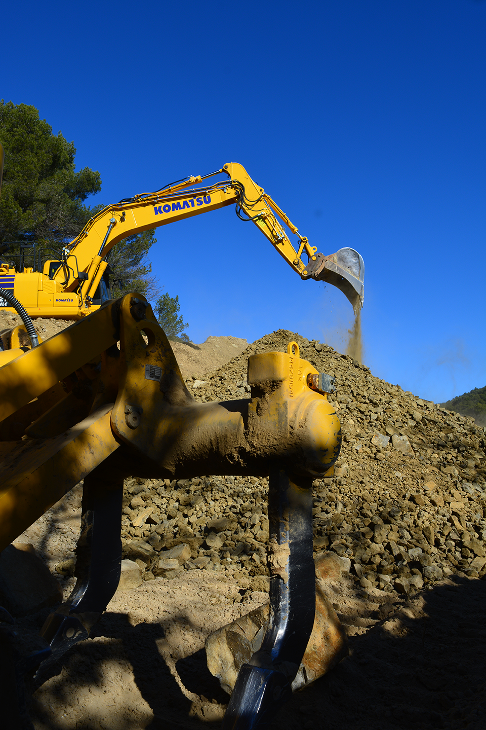 En gros plan griffes pour arrachage de vignes et en arrière plan la grosse pelle qui déverse de la terre - Terrassement, VRD, Aménagements paysagers Enrochement, Assainissement et démolition GUILLAUME TP 