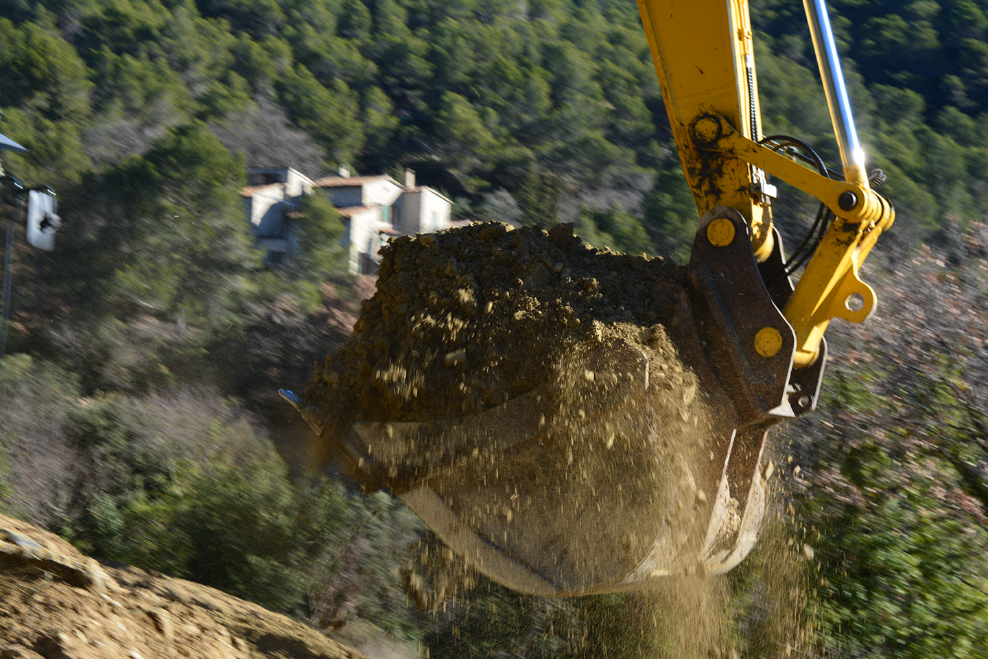 Godet en gros plan de la grosse pelle en train de transporter de la terre dans son godet, pour la page à propos de GUILLAUME TP Vaison-la-Romaine